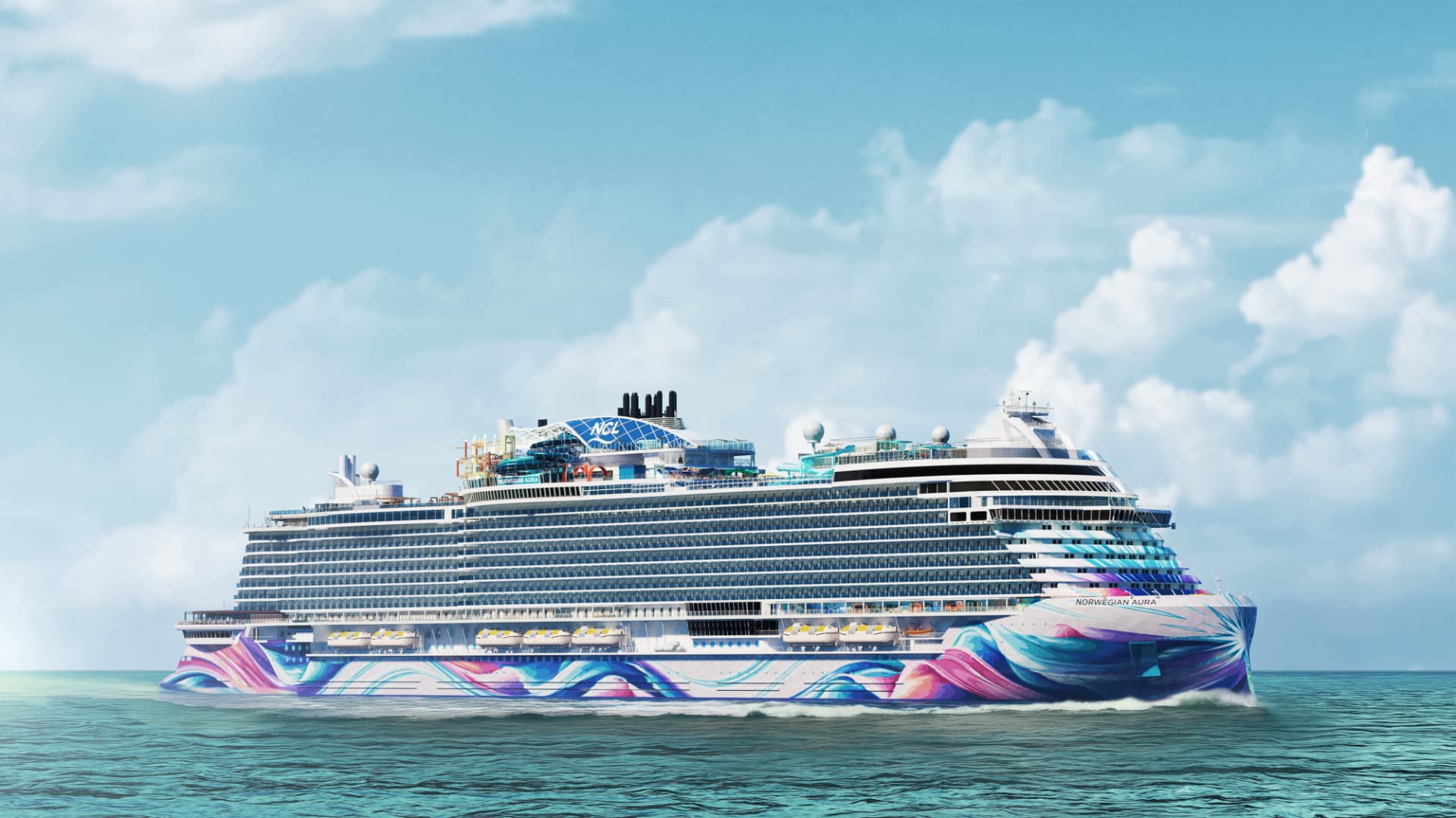 A Norwegian Cruise Line ship with a colorful painted hull sailing on turquoise water
