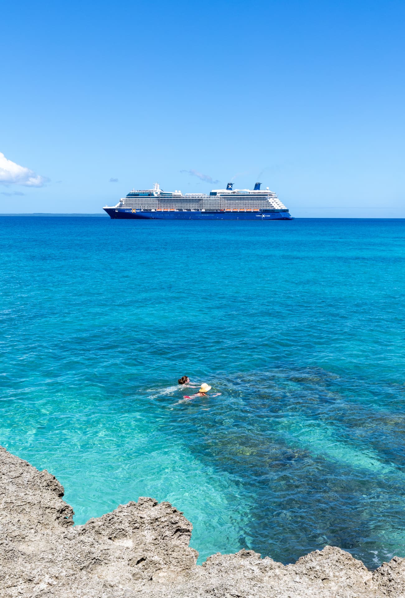 A cruise ship offshore in clear turquoise water.