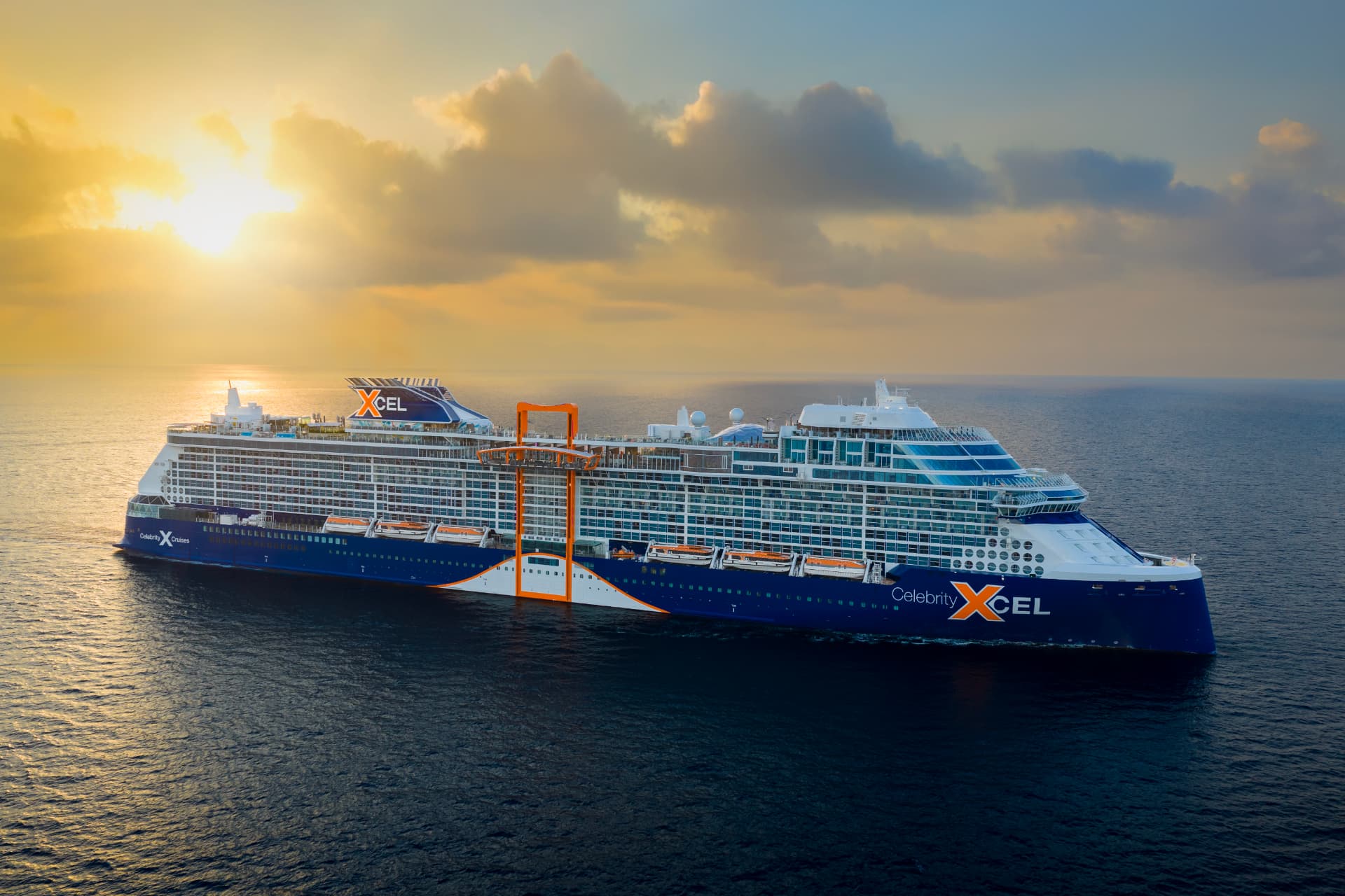 A Celebrity Cruises ship sailing beneath a warm sunset sky.